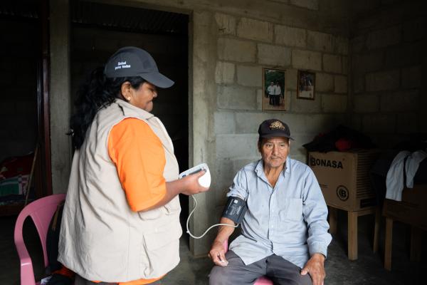 Trabajadora comunitaria de salud dandole seguimiento a un paciente